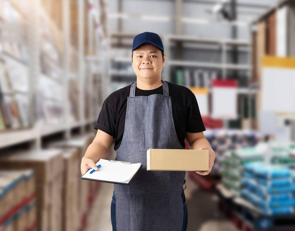 Male staff Delivering products Sign the signature on the product receipt form with parcel boxes Blurred the background of the warehouse - Foto, imagen