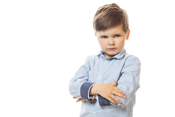 Young cute upset little boy posing on white background.  - Foto, imagen