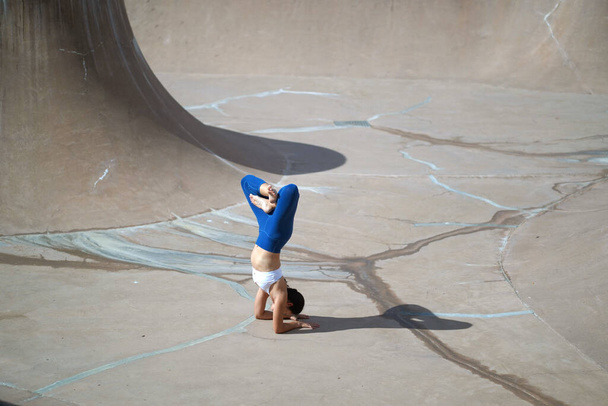 Suivant la tendance de faire du yoga dans les espaces publics, Asian Chinese Woman fait du yoga dans le skate park public
 - Photo, image