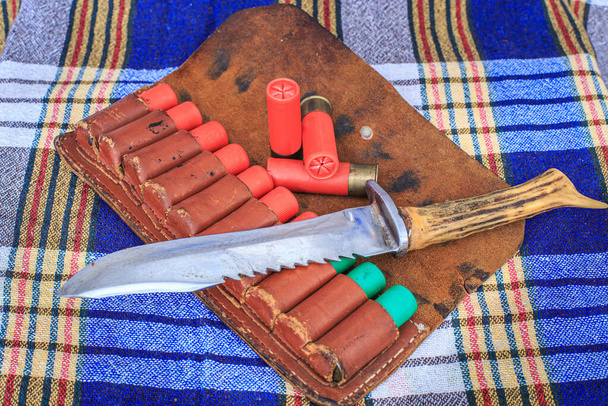 Couteau de chasse et cartouches pour fusil de chasse dans un bandoleer
 - Photo, image