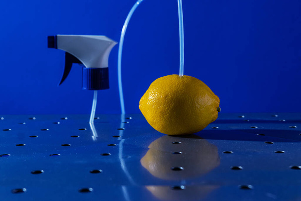 air freshener and window cleaner and lemon on a metal surface on a blue background - 写真・画像