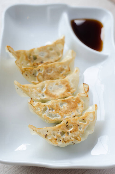 gyoza on white plate with sauce - Foto, afbeelding