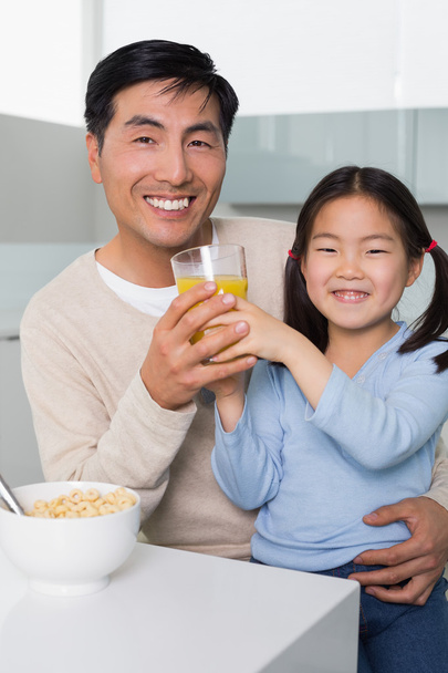 Happy father with daughter having breakfast in kitchen - Photo, image