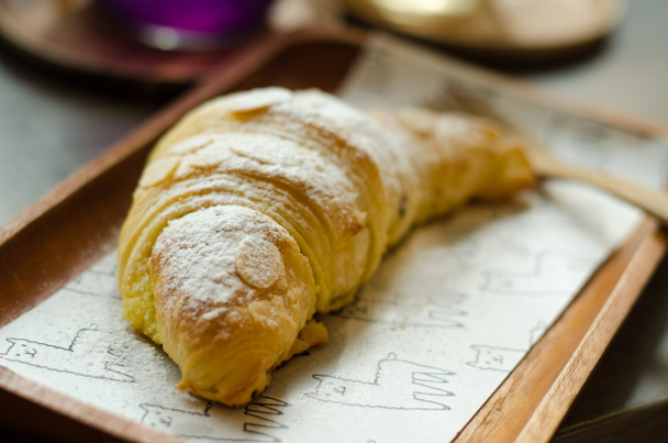 Francouzský croissant s polevou na dřevěné desce, koncept pekařství - Fotografie, Obrázek