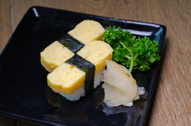 Des sushis aux œufs. sushi tamago sur assiette
 - Photo, image