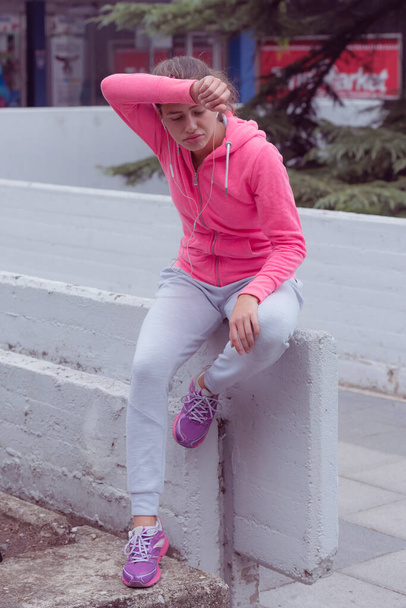 Young female runner prepairing for jogging in the city street. Fit body requires hard work. Urban sport concept. Young female exercising in sport clothes. - Foto, imagen