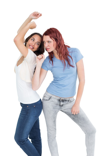 Two cheerful young female friends dancing - Foto, afbeelding
