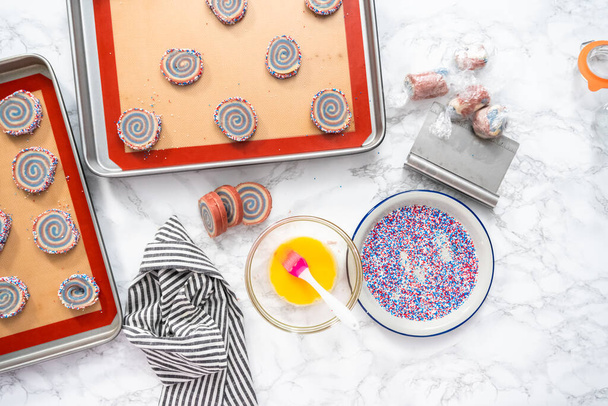 Flat lay. Baking red, white, and blue pinwheel sugar cookies for July 4th celebration. - Photo, Image