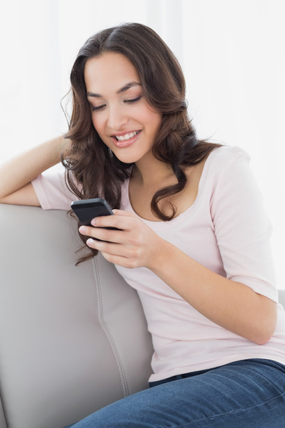 Relaxed woman text messaging on sofa at home - Fotoğraf, Görsel