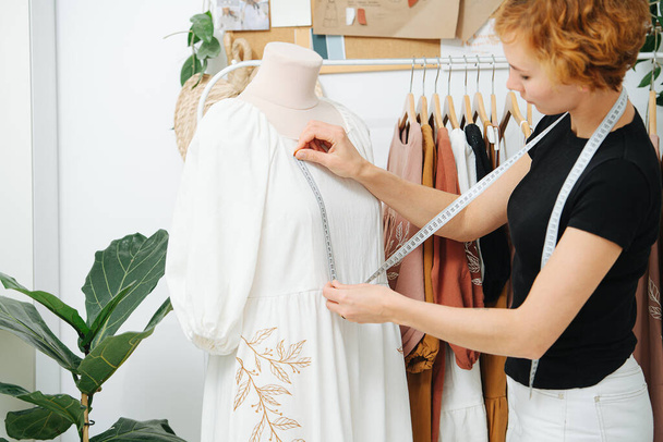 Tailor makes breast measurements on mannequin, work on new dress design - Foto, imagen