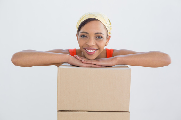 Portrait of a smiling young woman with boxes - Foto, afbeelding