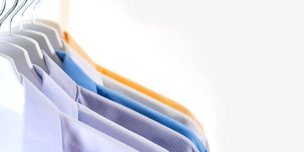 Nahaufnahme von Herrenhemden, Kleider auf Kleiderbügeln auf weißem Hintergrund - Foto, Bild