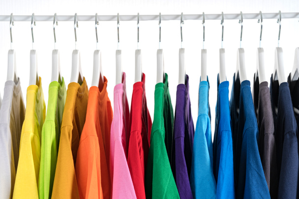 Close Up de t-shirts, Roupas em cabides no fundo branco
 - Foto, Imagem