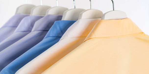 Close Up of Men's dress shirts, Clothes on hangers on white background - Photo, Image
