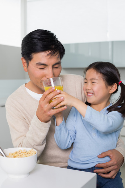 Father with daughter having breakfast in kitchen - Photo, image