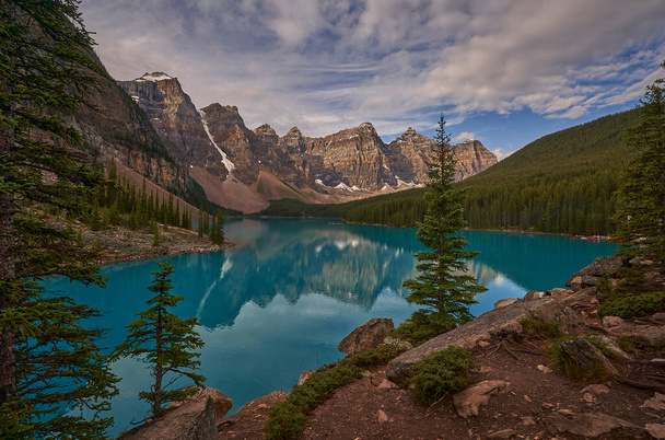 カナダのモレーン湖に反射している木 - 写真・画像