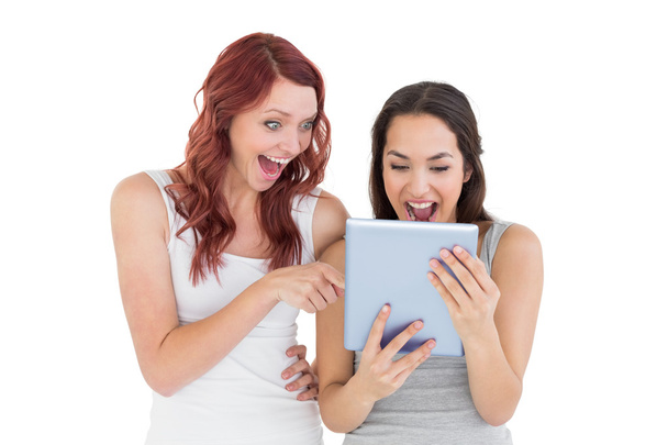 Shocked young female friends looking at digital tablet - Zdjęcie, obraz