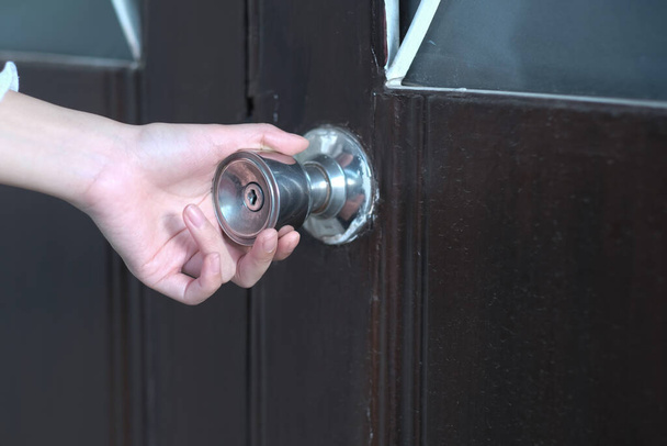 Een meisje opent de deurknop naar het huis  - Foto, afbeelding