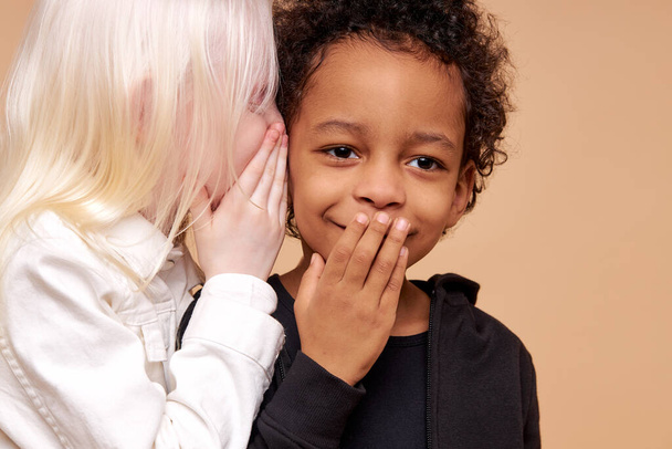 surprised afro boy and positive albino girl have secret - Фото, изображение
