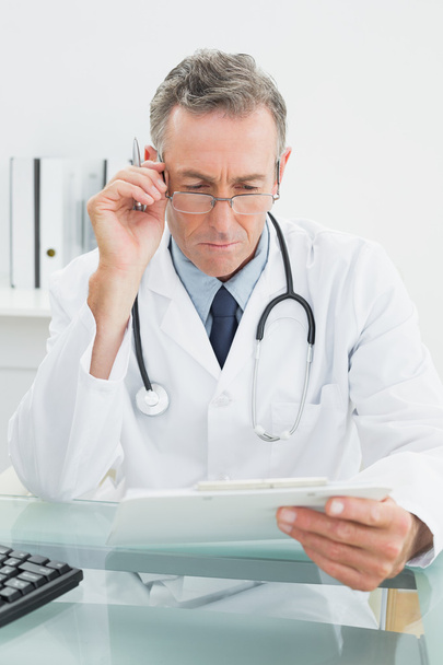 Doctor reading a report at medical office - Foto, imagen