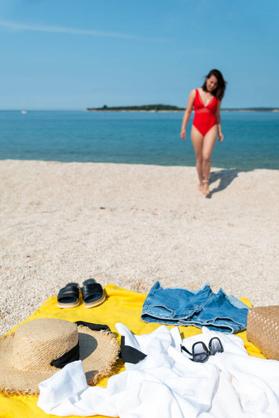 mladá hezká žena v červených plavkách na slunné mořské pláži. letní oblečení - Fotografie, Obrázek