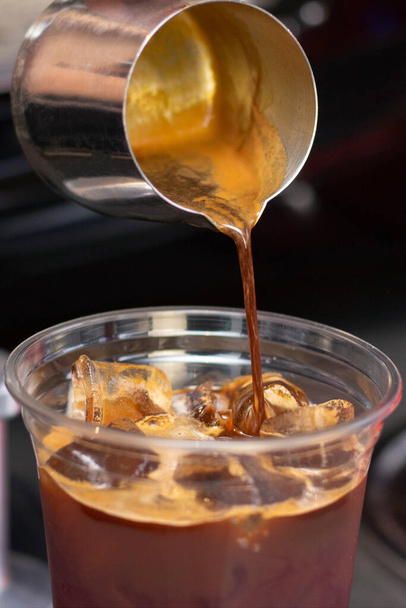 Ice coffee preparation preparation service concept. Barista. makes espresso in a coffee shop; close-up. Freshly ground coffee close up. vertical photo - Фото, зображення