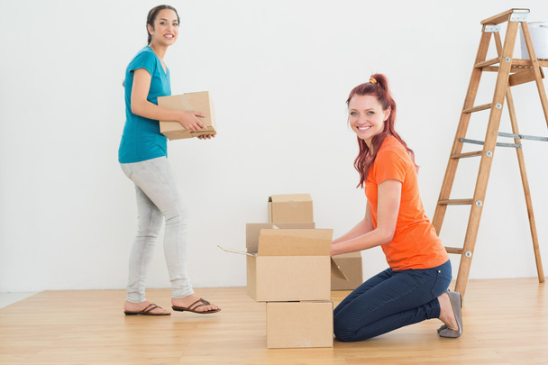 Portrait of two friends moving together in a new house - Photo, Image
