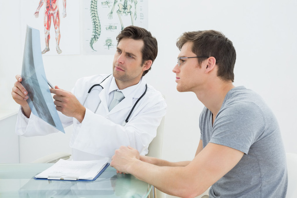 Male doctor explaining spine x-ray to patient - Zdjęcie, obraz