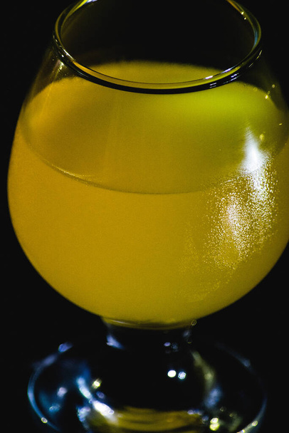 glass with orange juice on a black background - Фото, зображення