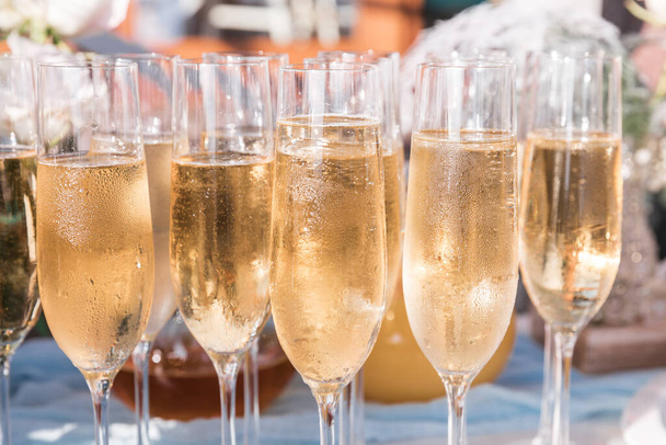 Copos de champanhe gelado em uma mesa com uma toalha de mesa para um deleite de boas-vindas para os hóspedes do evento
 - Foto, Imagem