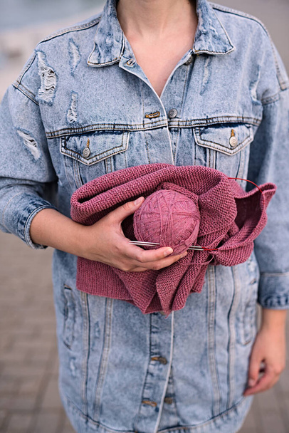 girl holds in her hands uterus of woolen threads, close-up - 写真・画像