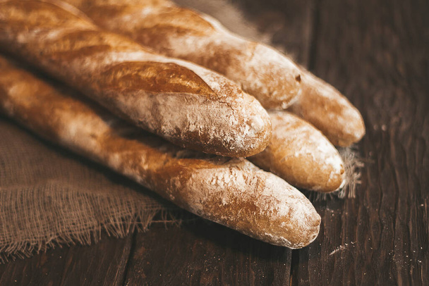 fresh baguettes on a wooden background - Photo, Image