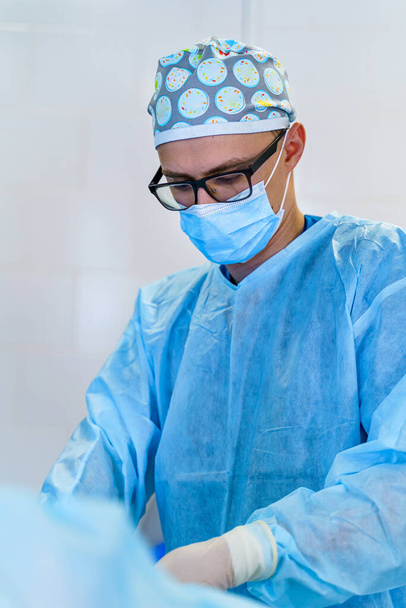 Doctor in operating room with surgery equipment. Doctor providing operation. Modern medical background - Foto, Imagem