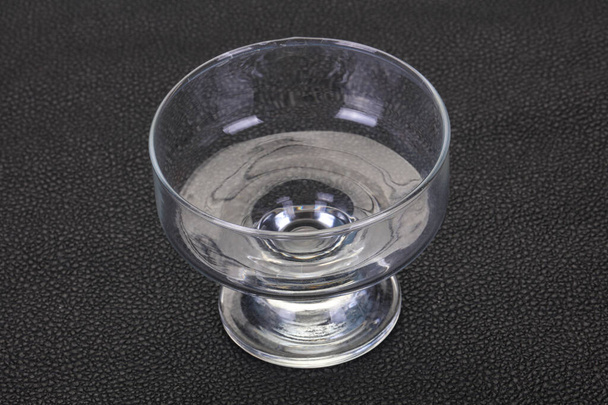 Пустая стеклянная чаша на черном фоне
 - Фото, изображение