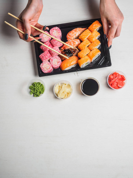 Ensemble de rouleaux de sushi dans des boîtes en plastique de livraison sur fond blanc
. - Photo, image