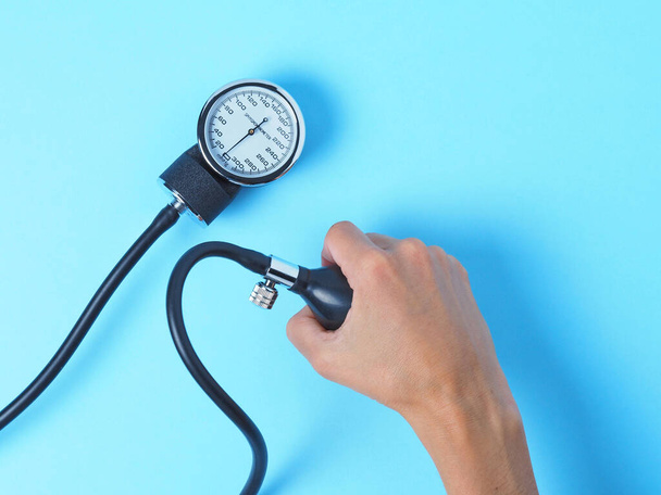 la mano de una mujer sostiene un monitor de presión arterial que muestra la presión arterial
 - Foto, Imagen