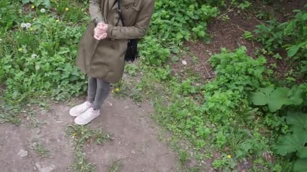 een meisje staat wrijven haar handen dan lopen langs een pad in een veld - Video