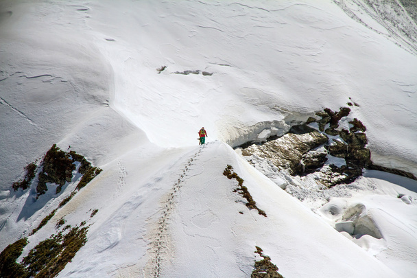 Skier climbing a snowy mountain - Photo, image