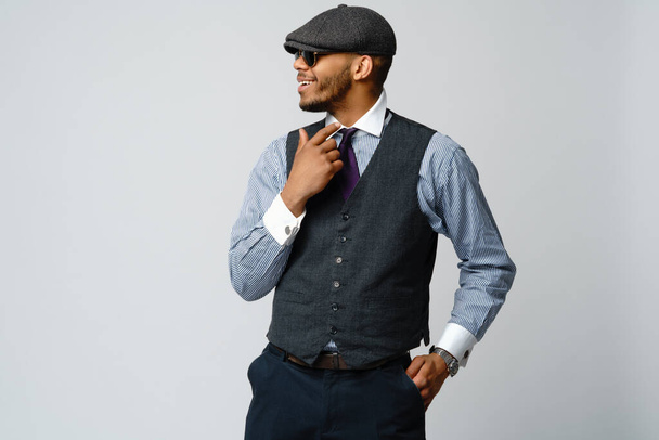 African-American man wearing cap, shirt and tie portrait over grey background - Foto, afbeelding