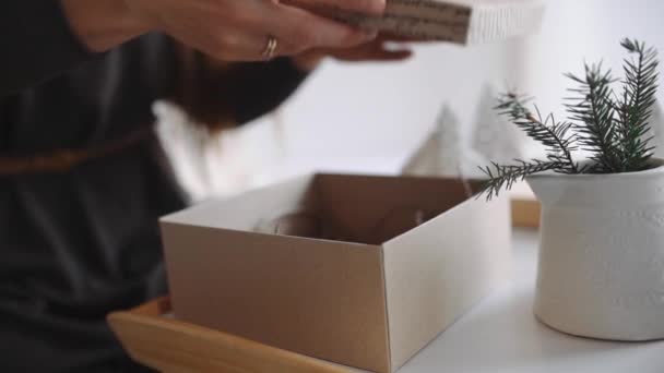 woman takes gifts to pack them christmas presents - Filmati, video