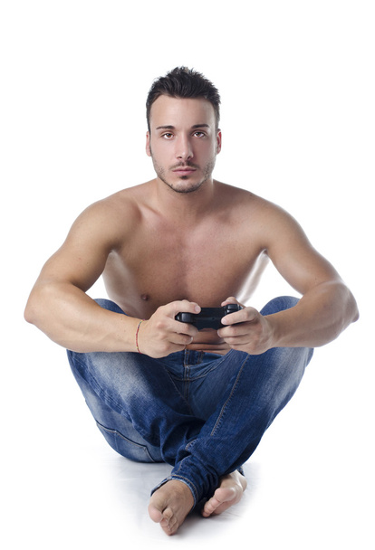 Handsome young man shirtless playing videogames with joypad - Zdjęcie, obraz