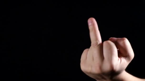 Man shows middle finger on black background. - Footage, Video