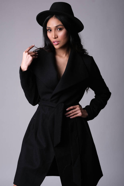 Elegante y elegante modelo asiático con abrigo negro y sombrero.. - Foto, imagen