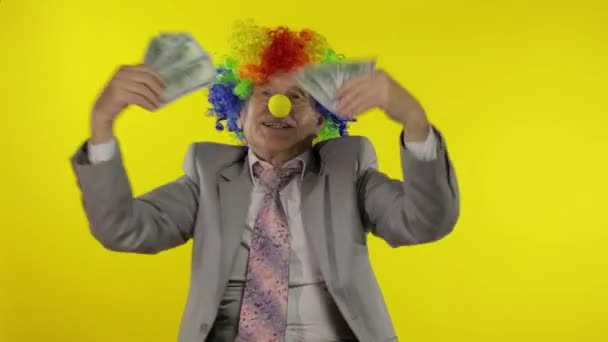 Anciano payaso empresario freelancer bailando con billetes de dinero en efectivo en dólares
 - Metraje, vídeo
