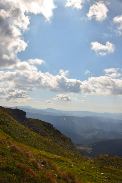 Blick von der Bergspitze auf das Tal vor dem Hintergrund grüner Berge und blauer Himmel mit Wolken - Foto, Bild