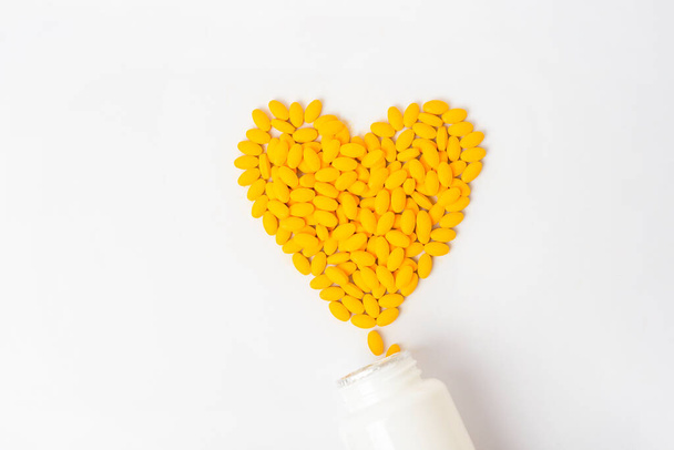 Heaps of yellow vitamins pills on white background  - Fotoğraf, Görsel