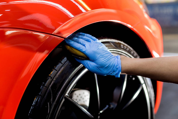 Car service worker polishing car wheels with microfiber cloth. - Fotoğraf, Görsel