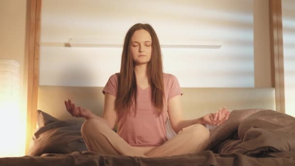 morning yoga woman sitting lotus pose bedroom - Materiał filmowy, wideo