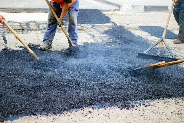 Travailleurs sur asphalte machine de pavage pendant les travaux de réparation de la rue
 - Photo, image