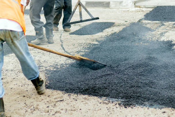 Travailleurs sur asphalte machine de pavage pendant les travaux de réparation de la rue
 - Photo, image